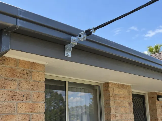 Overhead service cable and bracket mounted on a brick house fascia in Wadalba