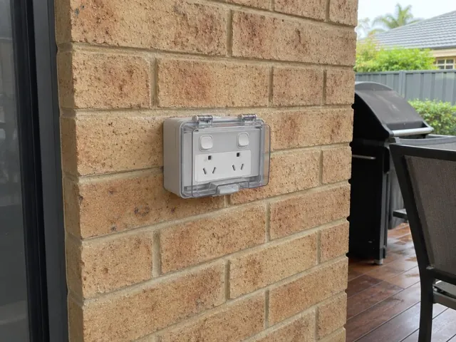 Outdoor double power point with weatherproof cover on a brick wall in Warnervale